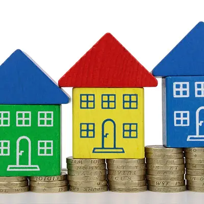 Image of blocks in the shape of houses on top of coins